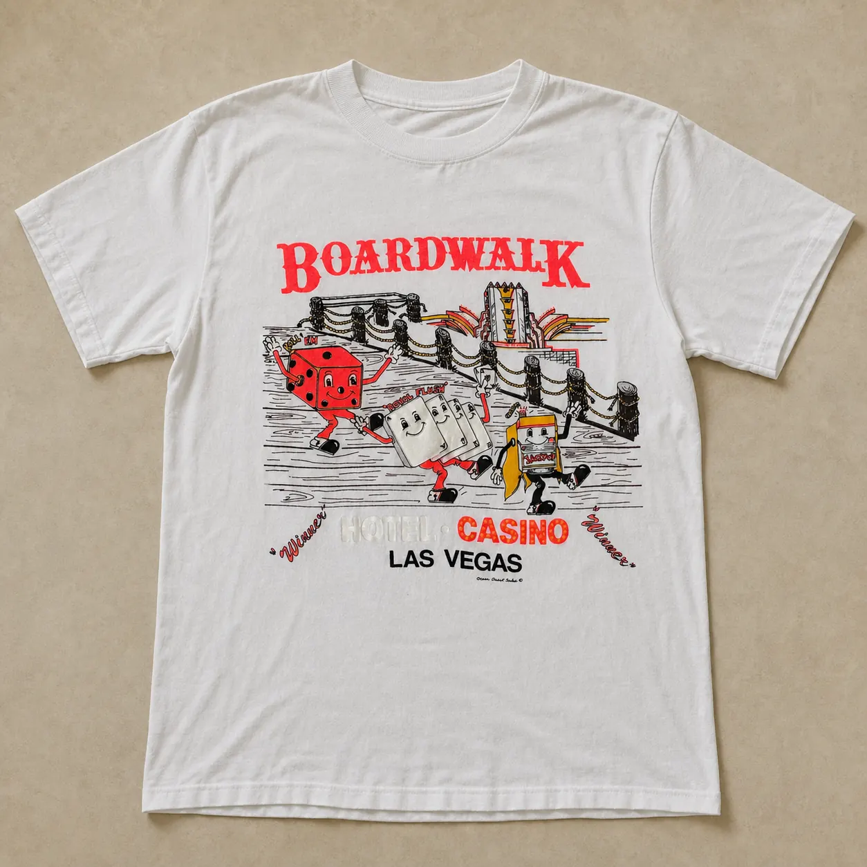 White Boardwalk souvenir T-shirt with the red Boardwalk logo and cartoon dice, cards and slot machine walking along a boardwalk.
