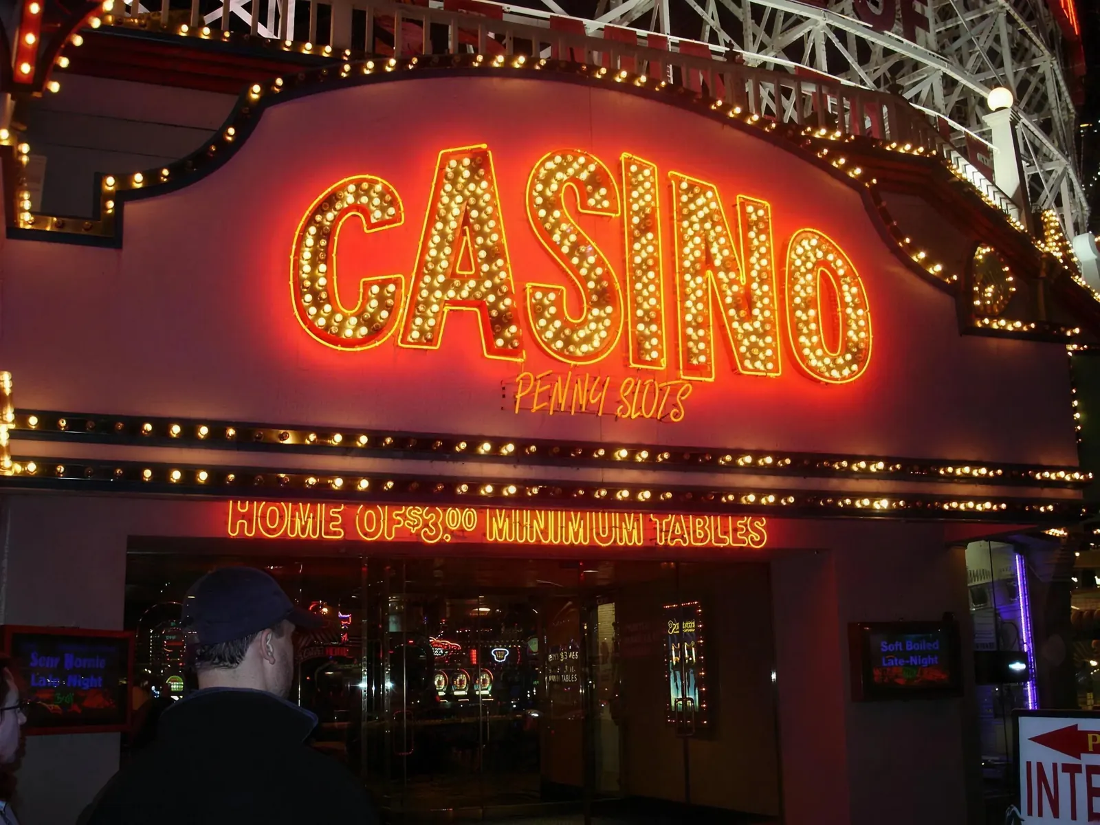 The Boardwalk casino entrance glowing at night with Casino, Penny Slots and Home of Three Dollar Minimum Tables signs.