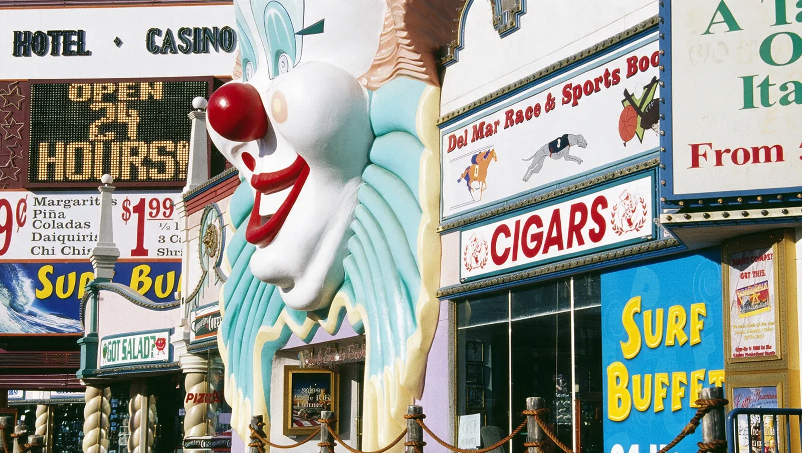 The Boardwalk by day, with Jocko above the casino entrance and the facade crowded with signs for drinks, the race and sports book, cigars and the Surf Buffet.