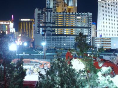 Night photo minutes before the implosion: the gutted sixteen-story Boardwalk tower stands floodlit and stripped of windows behind construction fencing, the Strip's lit hotels around it.