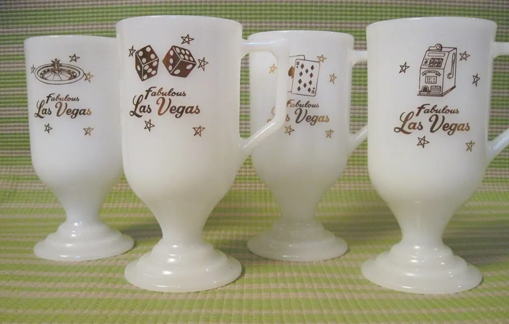 Four frosted pedestal mugs decorated with dice, roulette, playing cards and a slot machine.